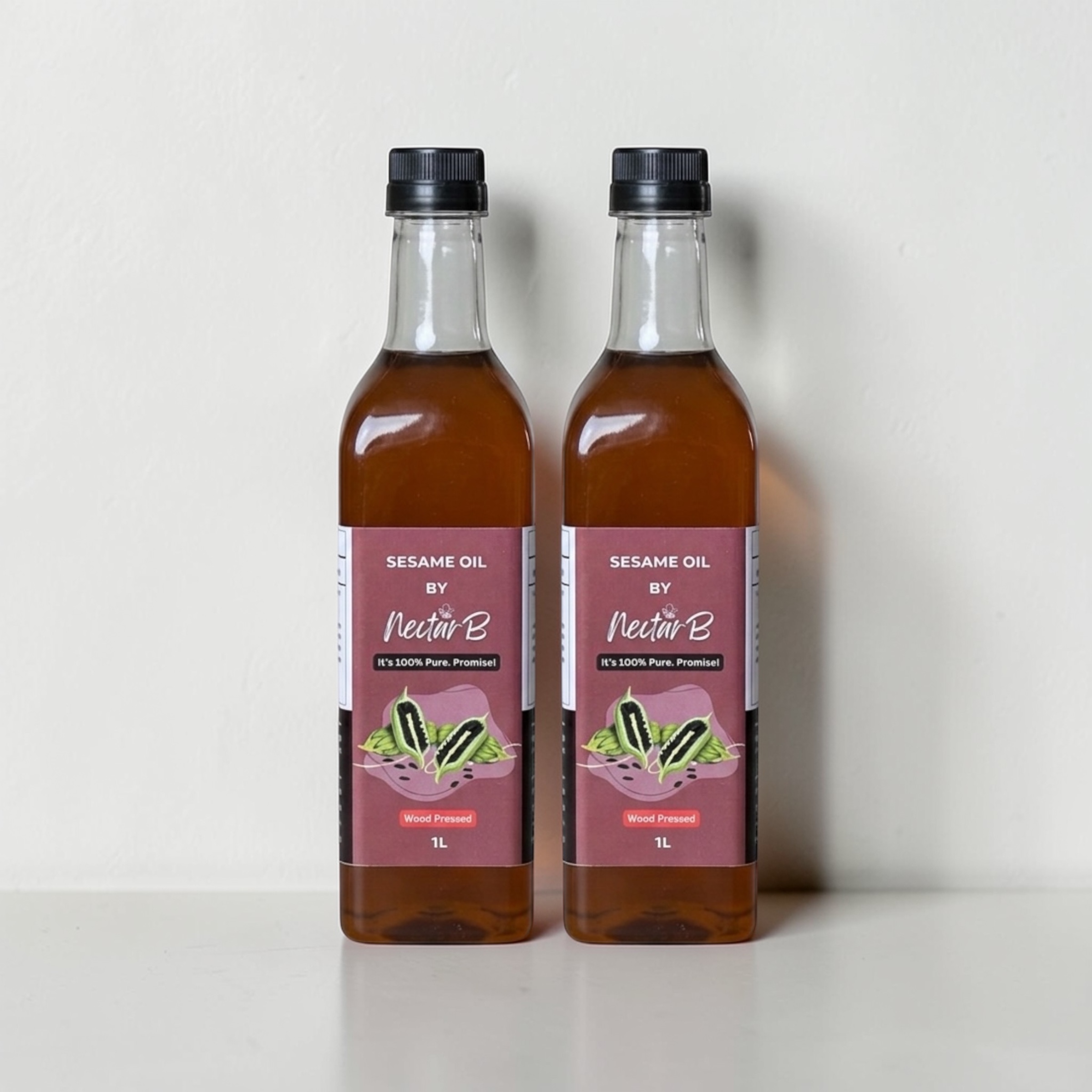 Wood Pressed Sesame Oil, 2L: two glass bottles of dark red-brown oil, maroon labels